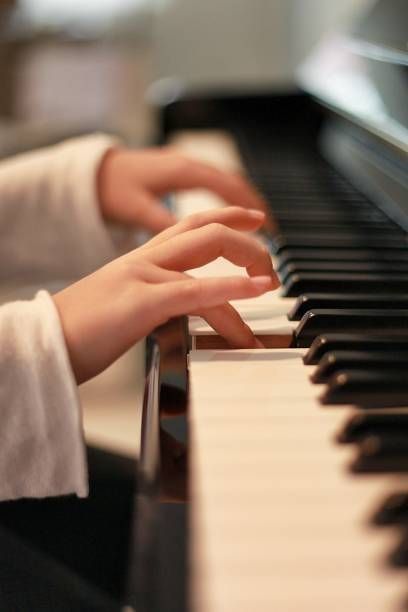 Young beginner’s hands exploring the piano